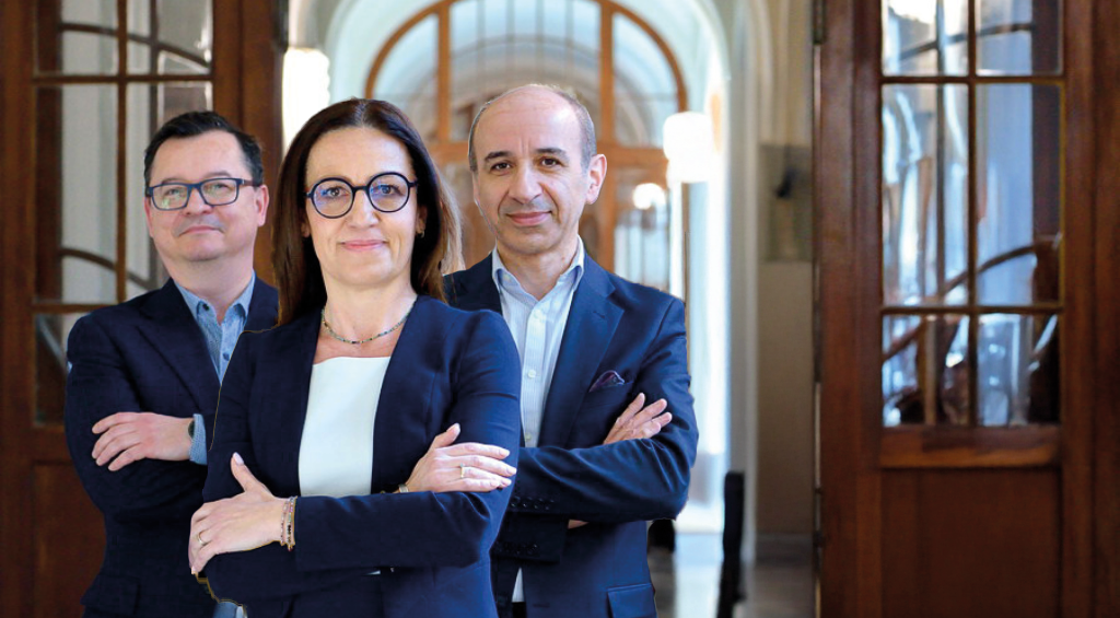 Trzy osoby stojące na tle korytarza PG