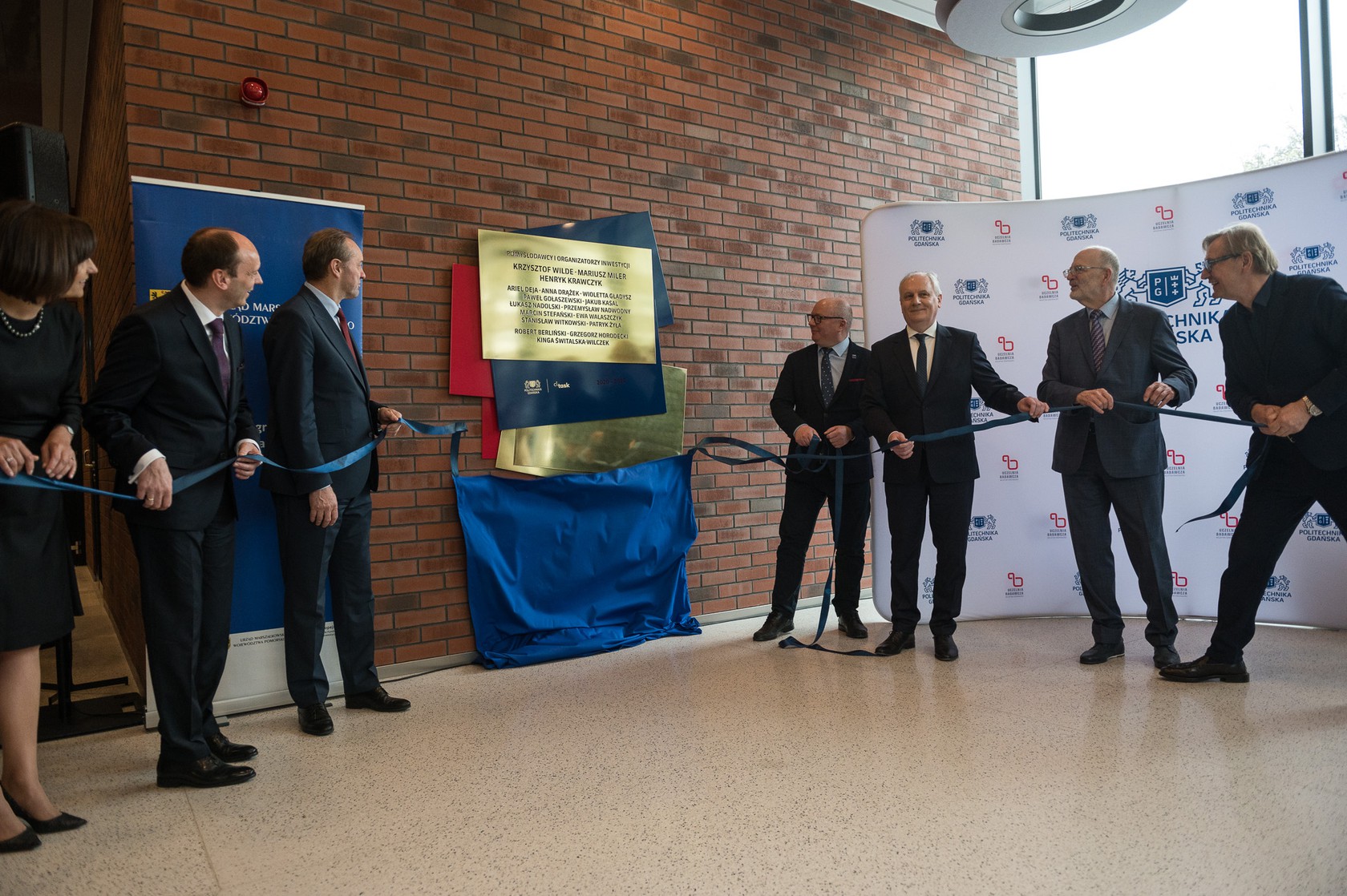 Odsłonięcie reliefu w budynku CK STOS. Od lewej: Małgorzata Winiarek-Gajewska, prezeska NDI, Mariusz Miler, kanclerz PG, Mieczysław Struk, marszałek woj. pomorskiego, prof. Krzysztof Wilde, rektor PG, Dariusz Drelich, wojewoda pomorski, prof. Henryk Krawczyk, arch. Zbigniew Reszka, projektant CK STOS.