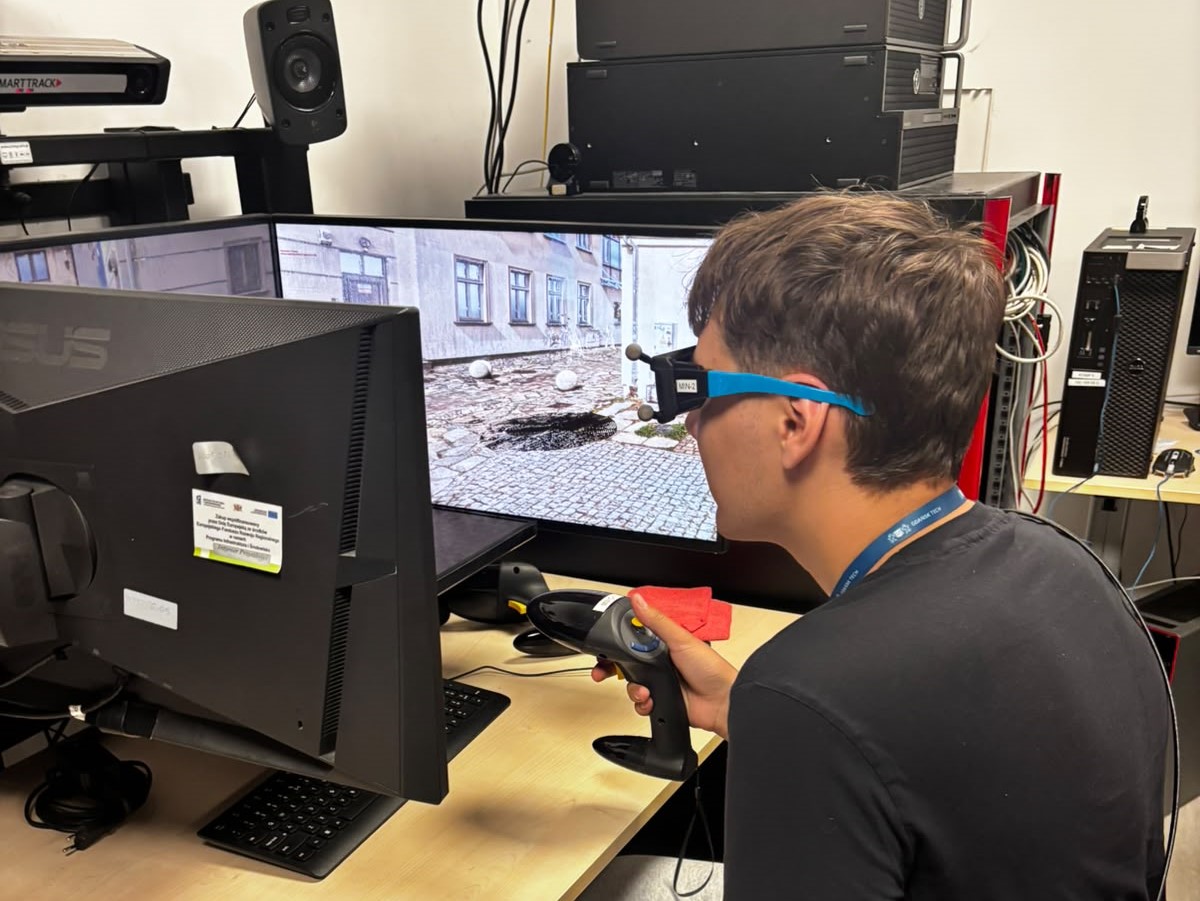 A photo of a PULA program participant wearing special glasses and holding a joystick at a virtual reality work desk setup.